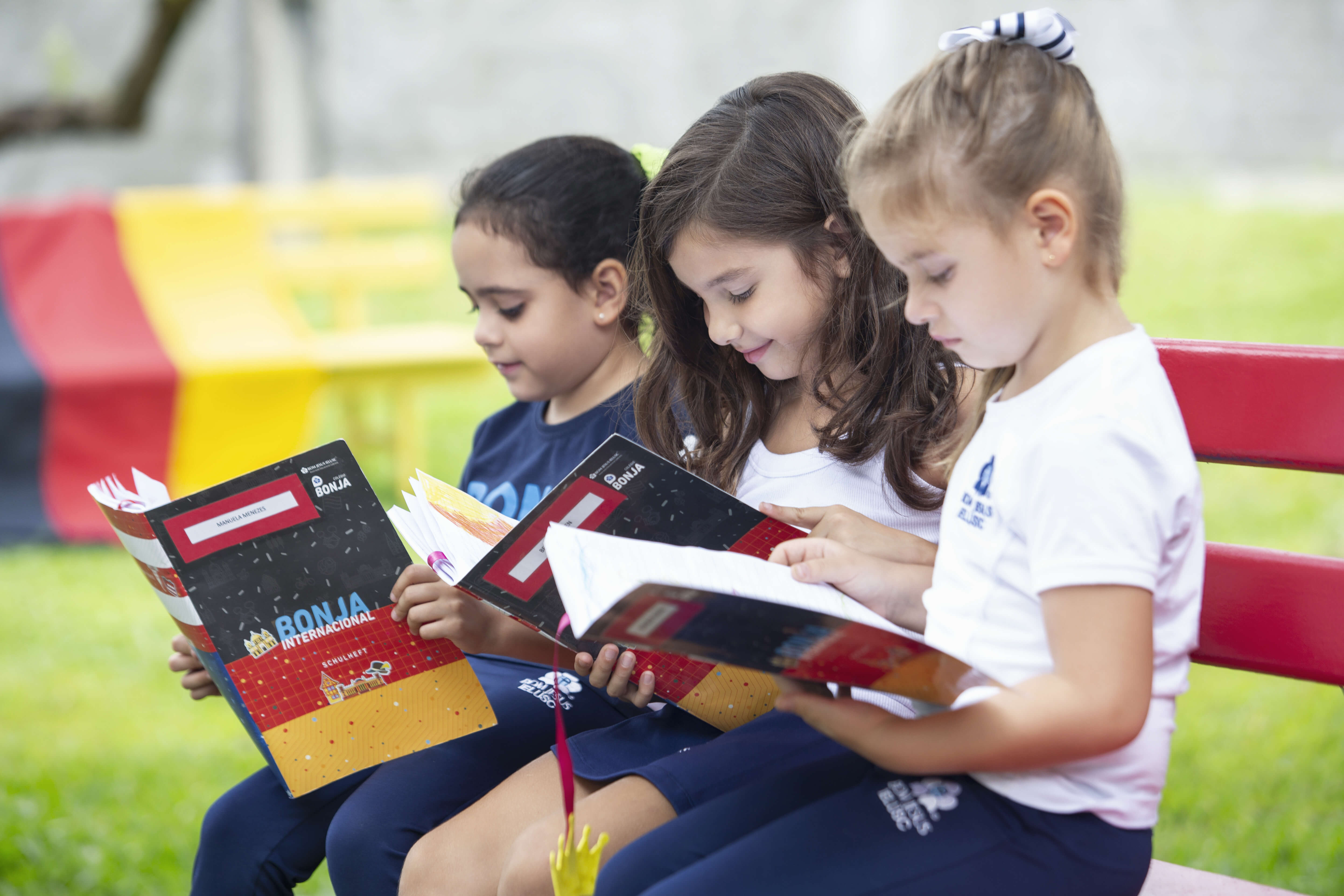 crianças lendo livros no banco do pátio