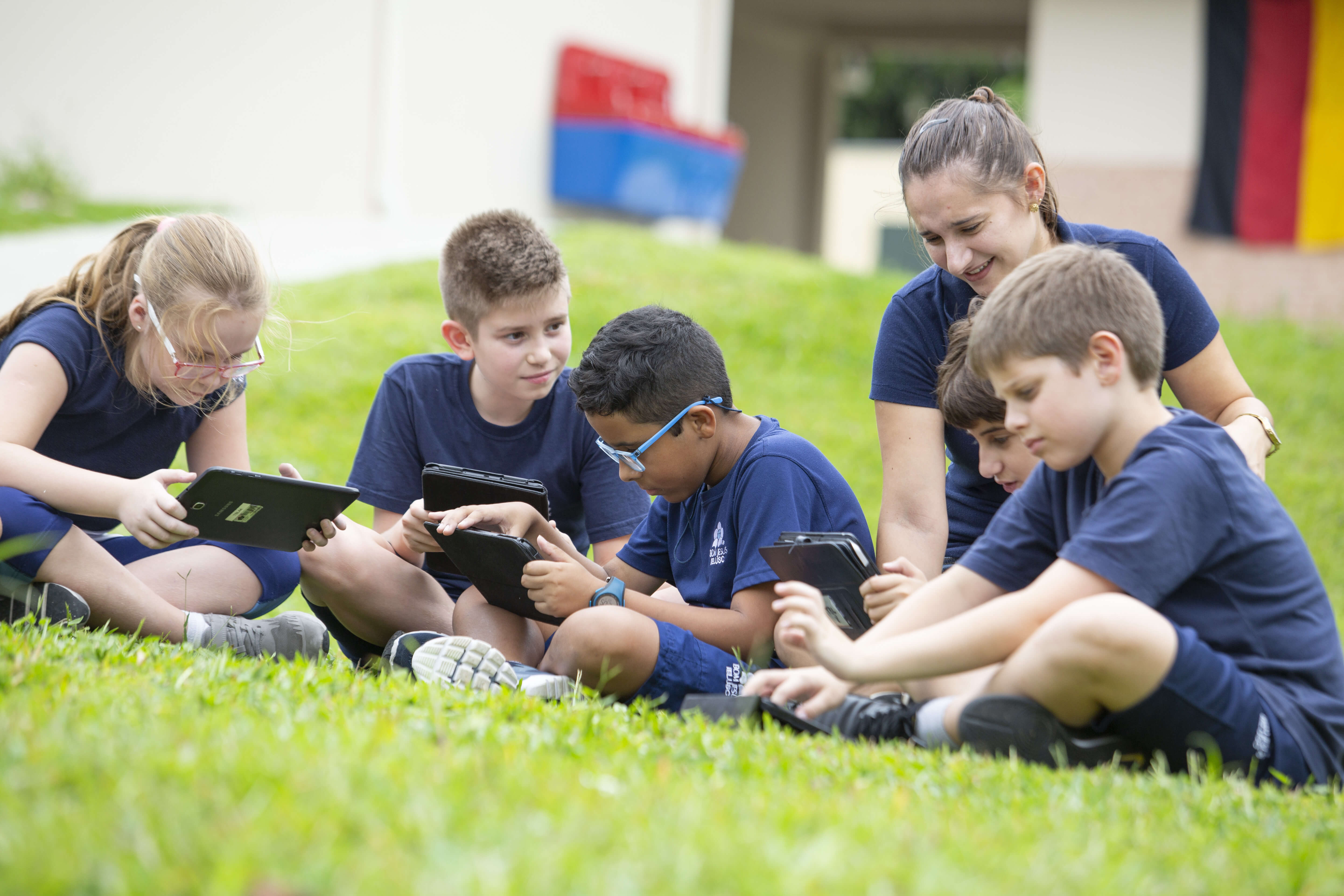 professora e alunos crianças estudando com tablet no gramado